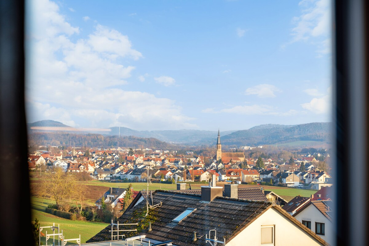 Malerischer Weitblick aus dem Dachfenster auf die Dächer von Goldbach und die Hügel