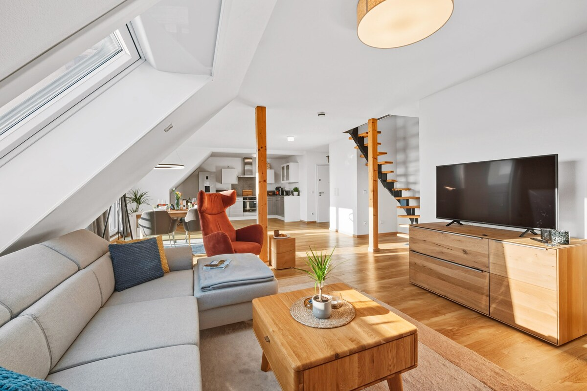 Wohnzimmer mit flachem TV-Board und Blick auf das Sofa und die Küche im Hintergrund