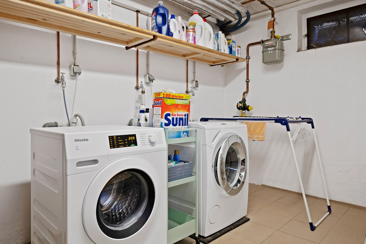 Hauswirtschaftsraum mit Miele Waschmaschine und Trockner sowie Waschmitteln